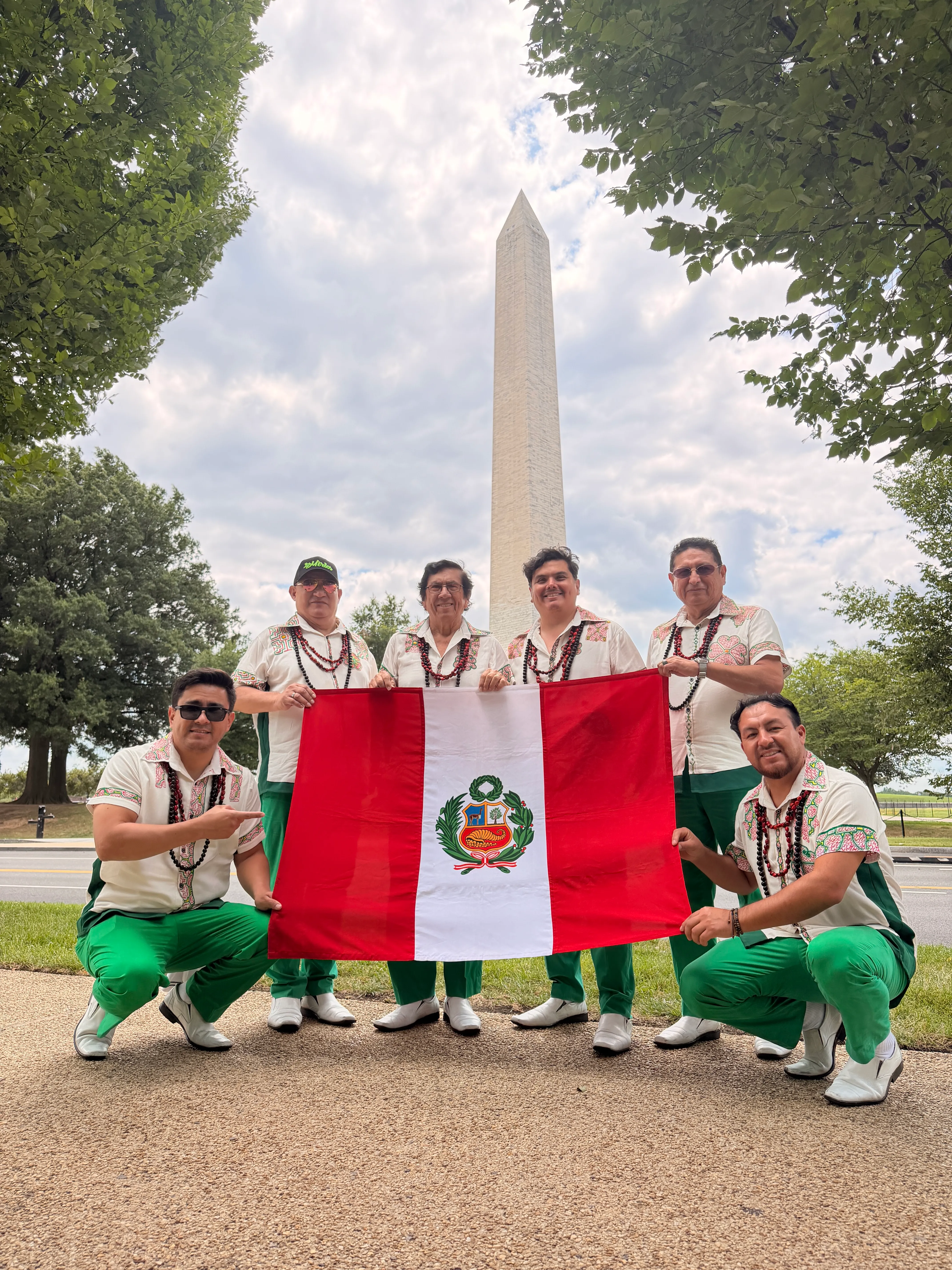 Los Mirlos hold a Peruvian flag in front of the Washington Monument